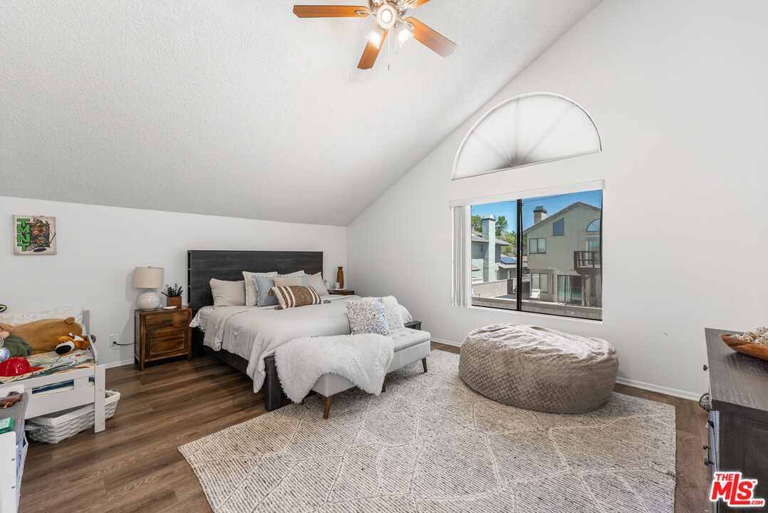 43258 33rd Street West Lancaster, CA 93536 - Photo 25 of 38 a spacious bedroom with a bed a window and a chandelier