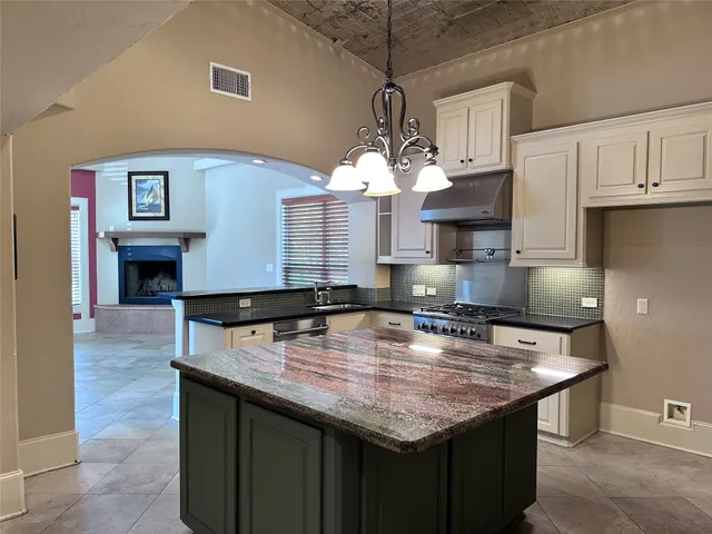 a kitchen with kitchen island a counter space a sink appliances and cabinets