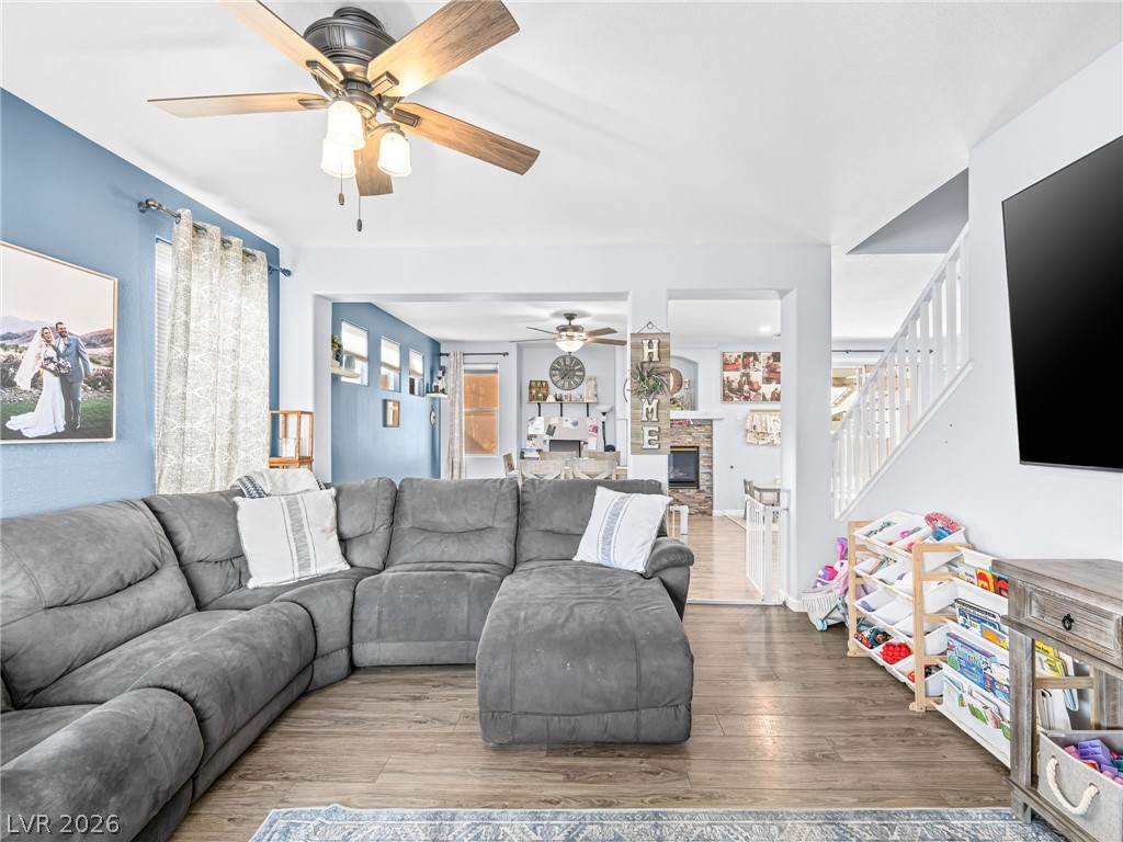 iving area with ceiling fan, and luxury vinyl plank flooring, baseboards.