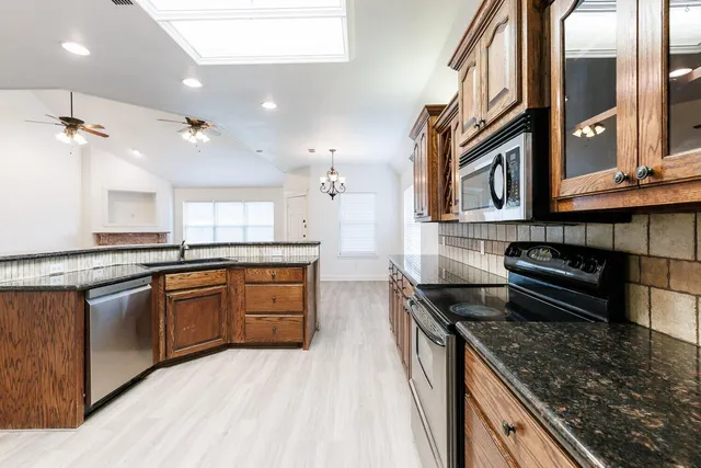 a kitchen with stainless steel appliances granite countertop a stove and a sink