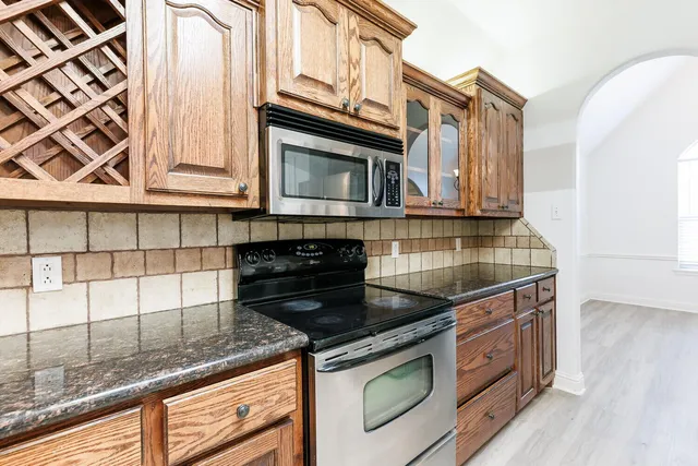 a kitchen with stainless steel appliances granite countertop a stove and a microwave