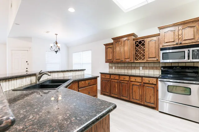 a kitchen with stainless steel appliances granite countertop a sink and a stove