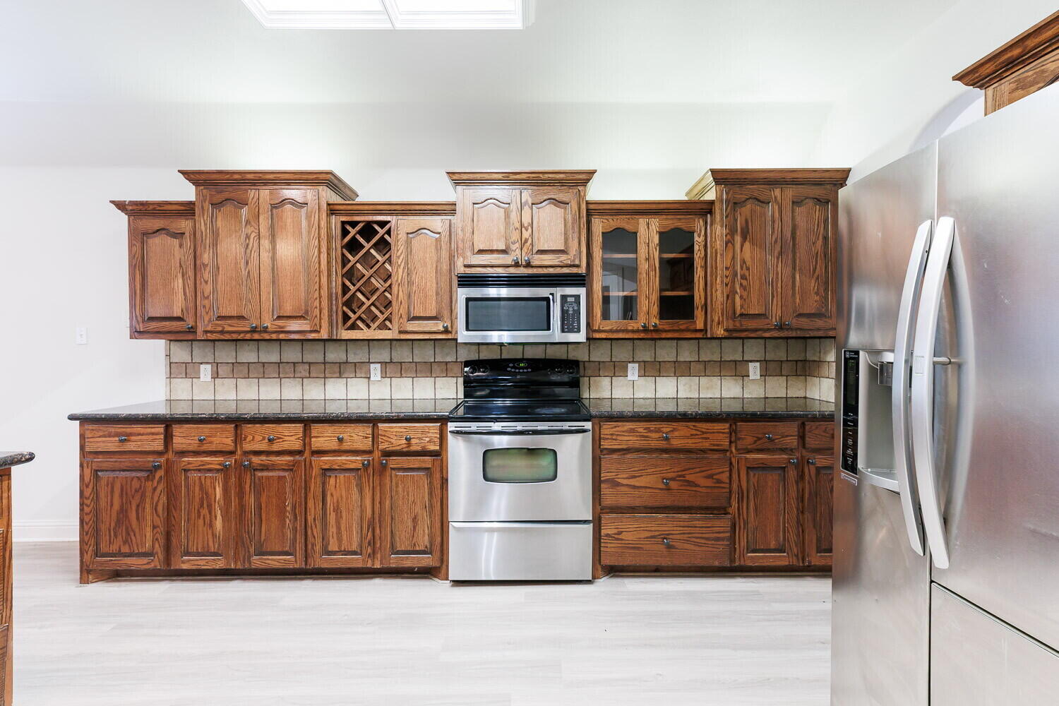5908 95th Street Lubbock, TX 79424 - Photo 15 of 45 a kitchen with stainless steel appliances granite countertop a refrigerator and a stove