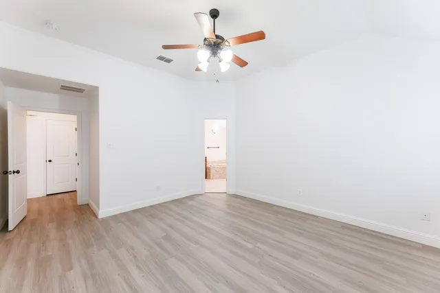 a view of an empty room with wooden floor