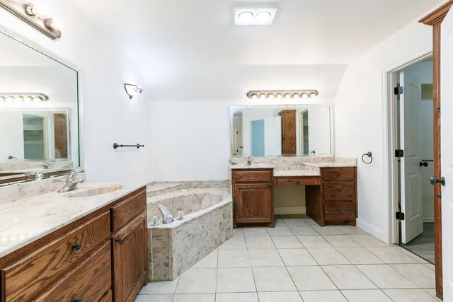 a bathroom with a granite countertop sink mirror and bathtub