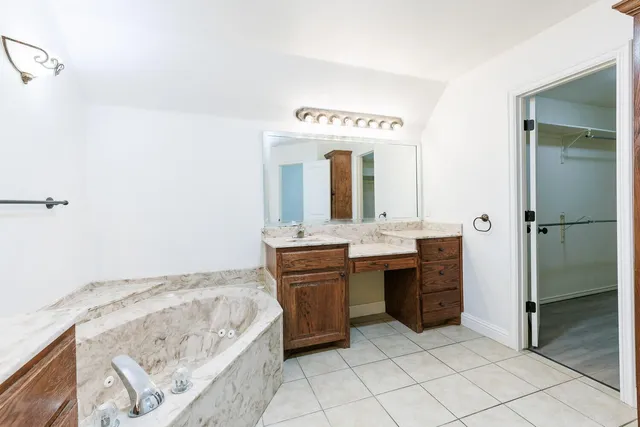 a spacious bathroom with a granite countertop sink and a mirror
