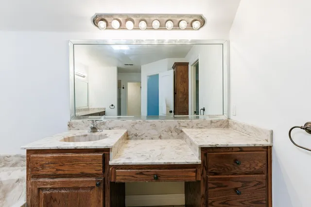 a bathroom with a granite countertop sink and a mirror