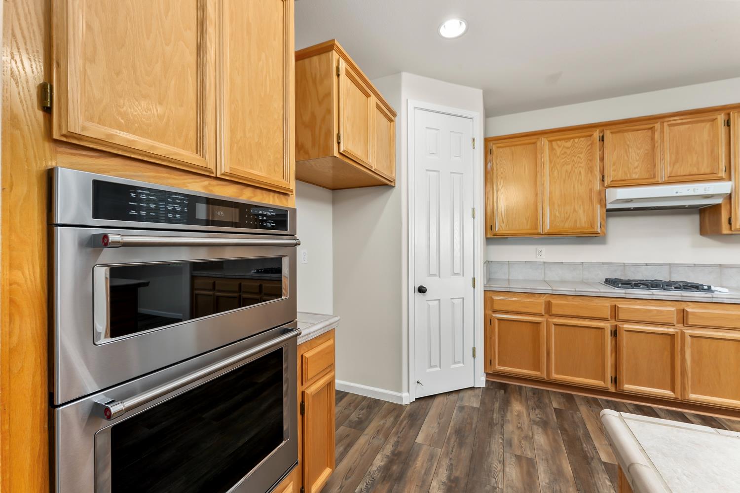 4285 Crazy Horse Road Cameron Park, CA 95682 - Photo 28 of 91 a kitchen with granite countertop cabinets stainless steel appliances and wooden floor