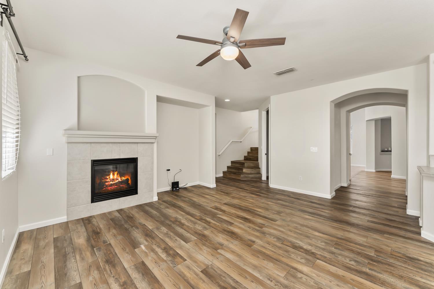 4285 Crazy Horse Road Cameron Park, CA 95682 - Photo 37 of 91 a view of an empty room with wooden floor fireplace and a window