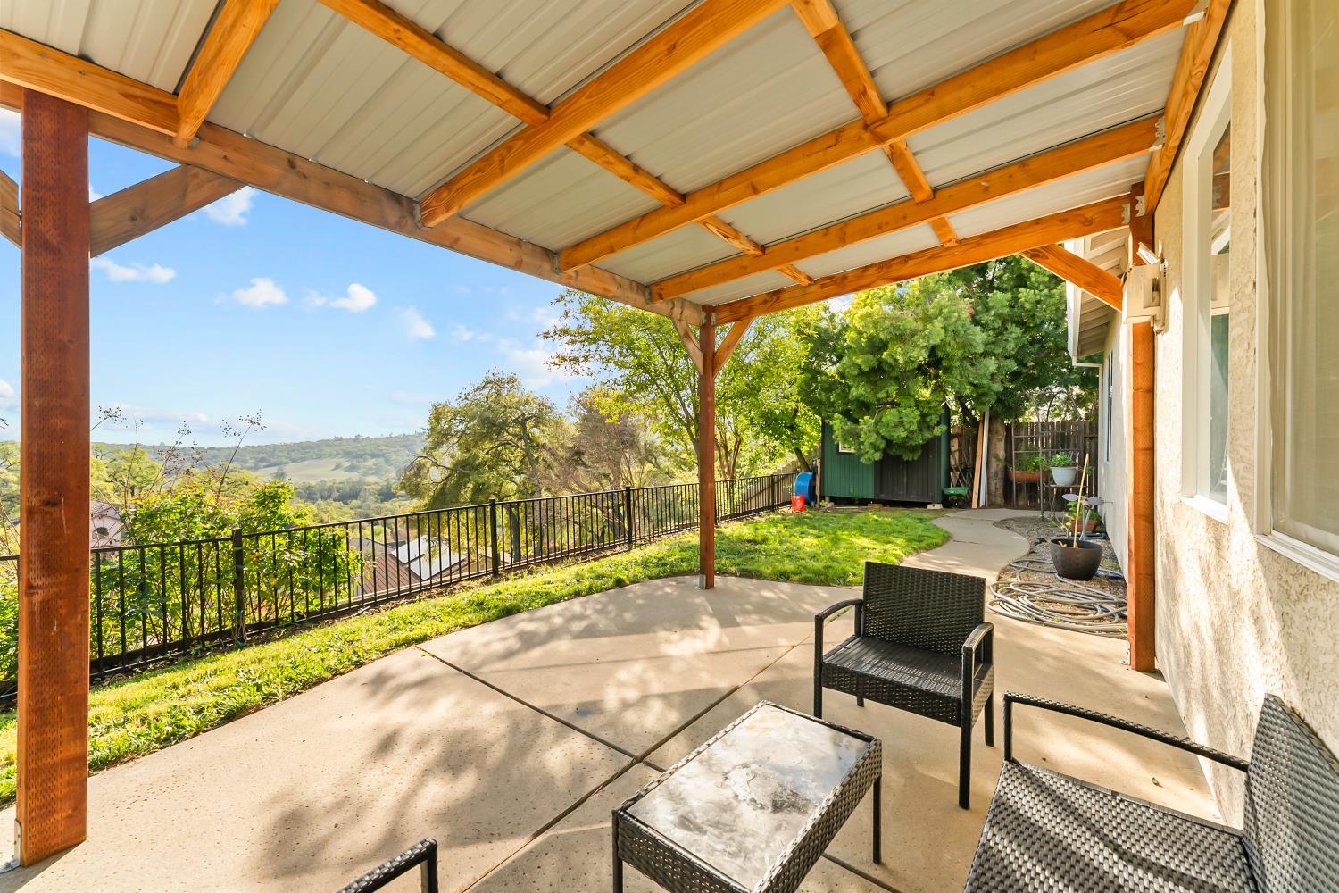 4285 Crazy Horse Road Cameron Park, CA 95682 - Photo 69 of 91 a view of a patio with a table and chairs under an umbrella