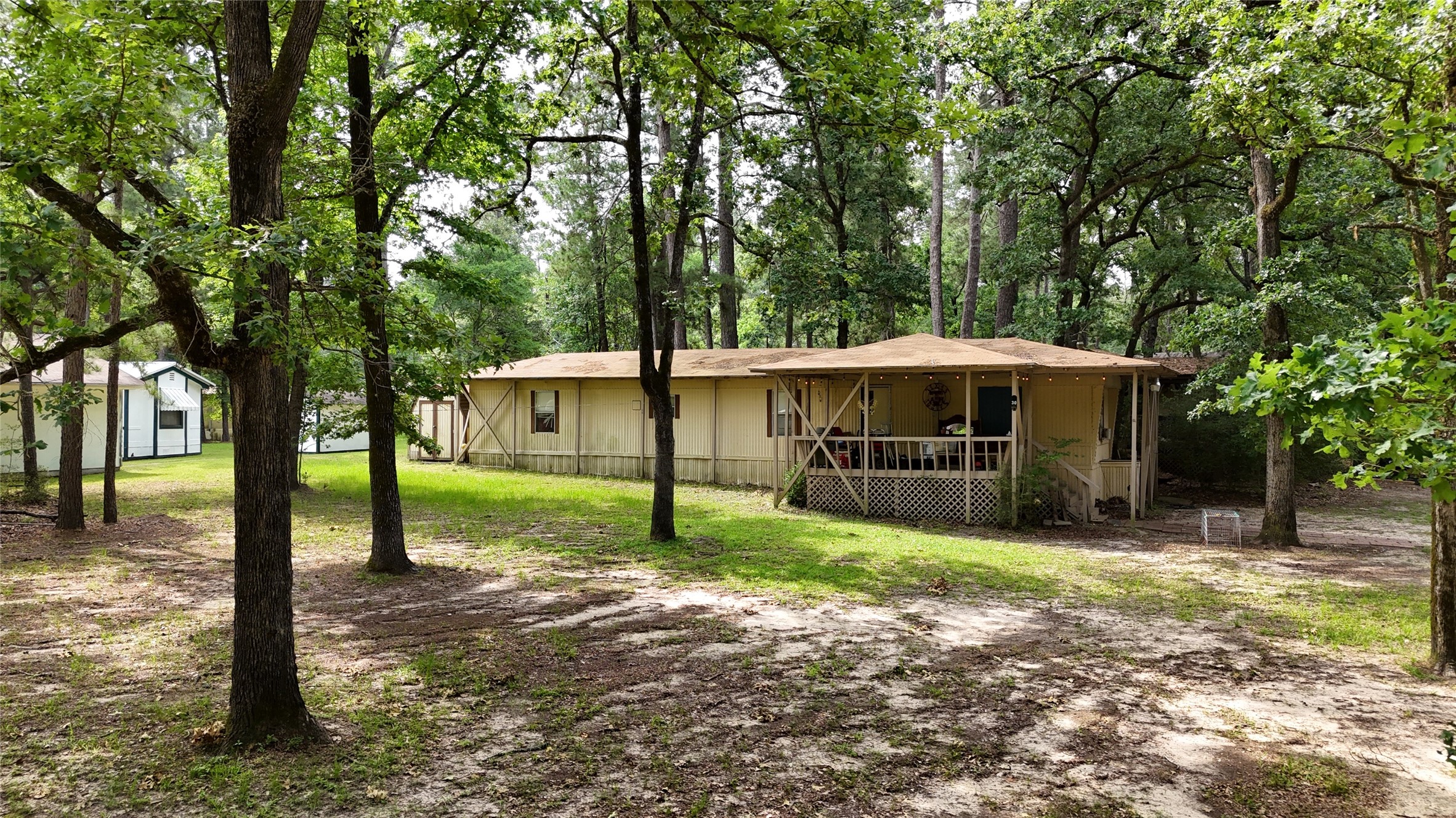 a view of a house with a yard and large trees