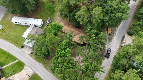 an aerial view of residential house with outdoor space and trees all around