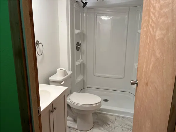 a bathroom with a toilet a sink and shower