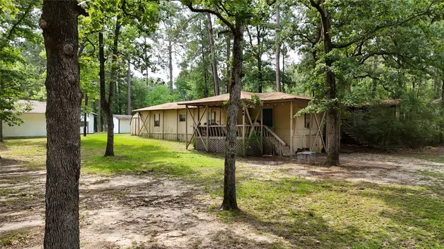a view of a house with backyard and trees