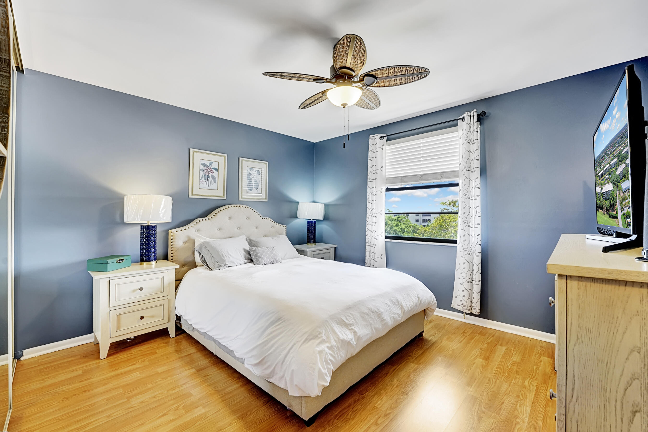 6097 Balboa Circle, Unit 406 Boca Raton, FL 33433 - Photo 17 of 28 a bedroom with a bed and a chandelier