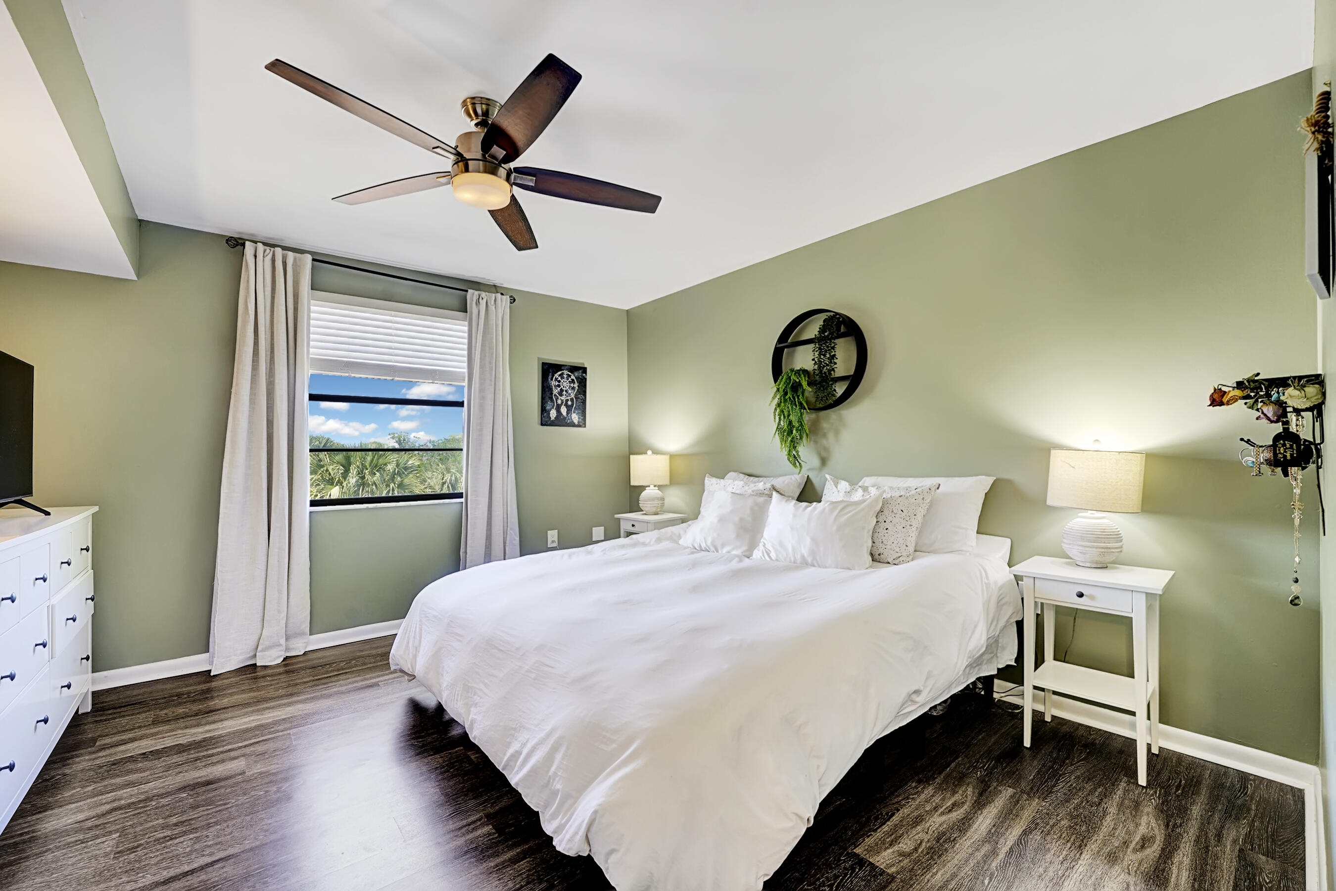 6097 Balboa Circle, Unit 406 Boca Raton, FL 33433 - Photo 20 of 28 a bedroom with a bed and a chandelier