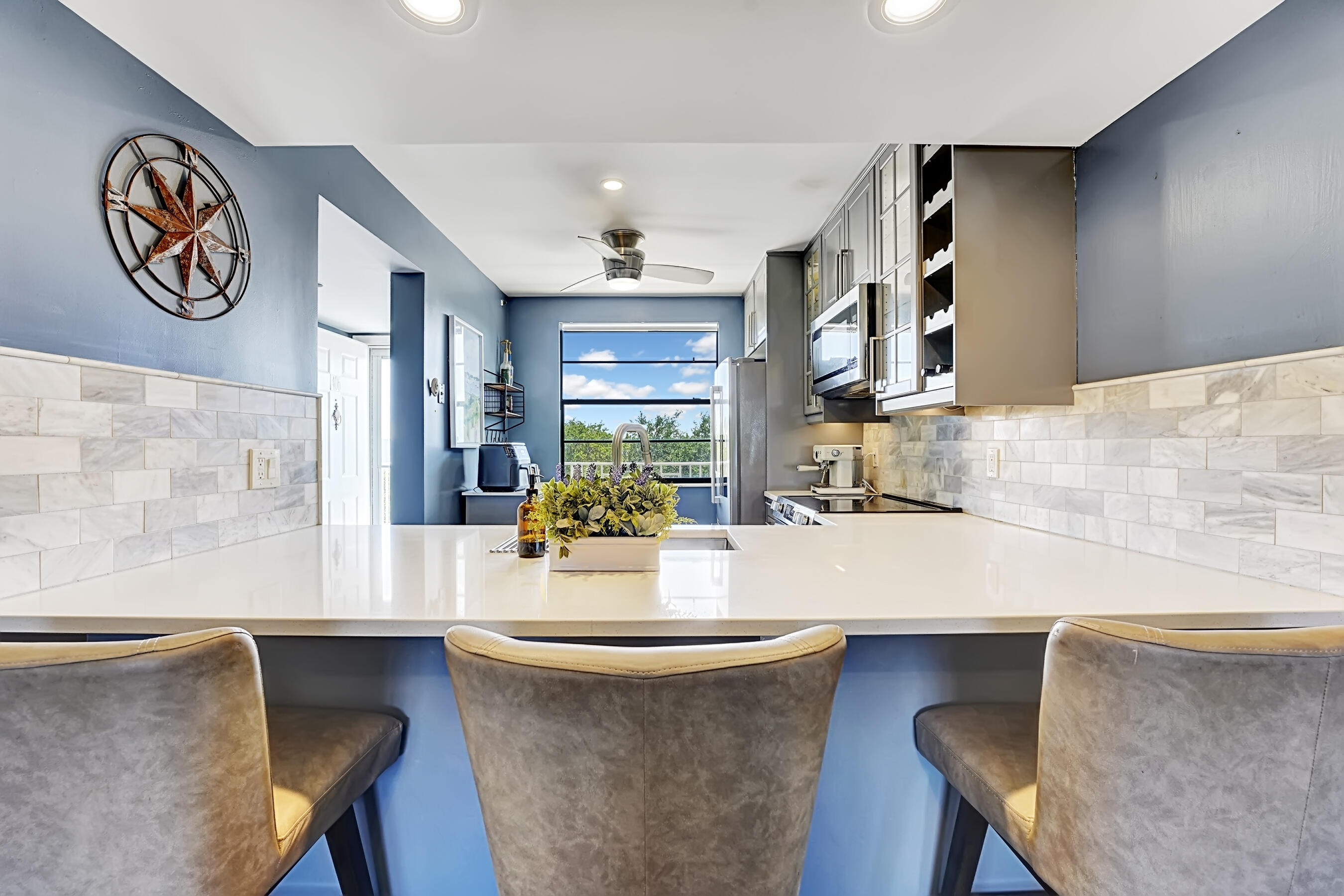 6097 Balboa Circle, Unit 406 Boca Raton, FL 33433 - Photo 10 of 28 a dining hall with granite countertop a sink a stove and a refrigerator with wooden floor