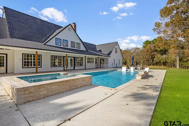 a house view with swimming pool and yard