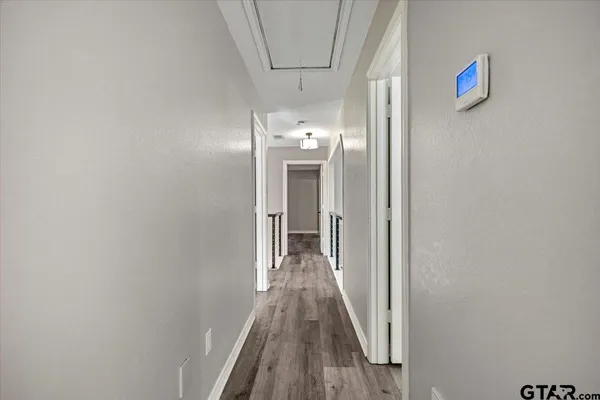 a view of a hallway with wooden floor and staircase