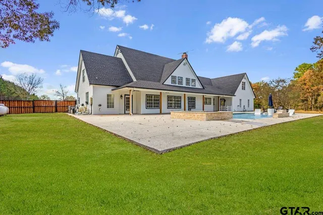 a front view of house with yard and trees in the background