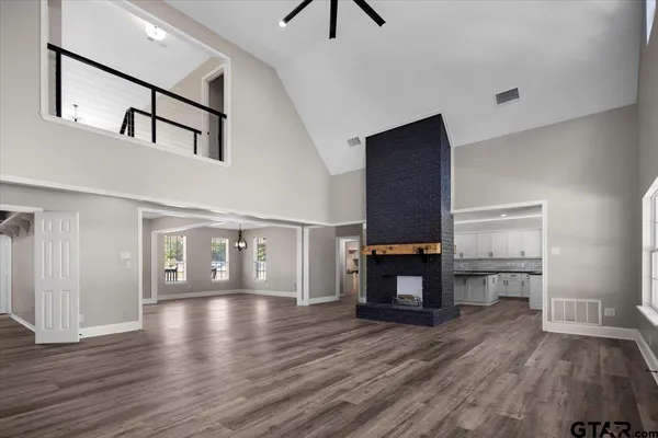 a view of empty room with wooden floor and fireplace