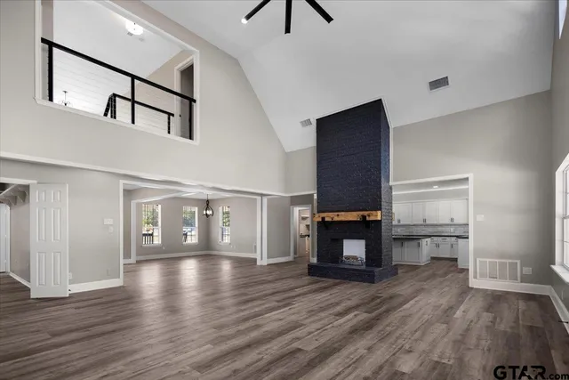 a view of empty room with wooden floor and fireplace