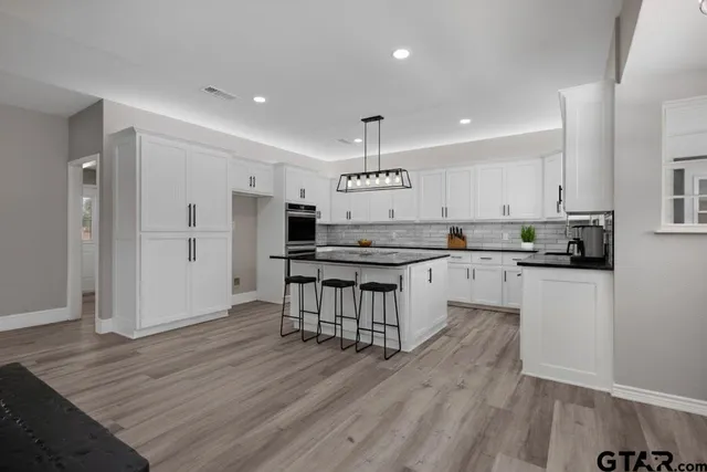 a kitchen with stainless steel appliances kitchen island granite countertop a refrigerator and a stove top oven