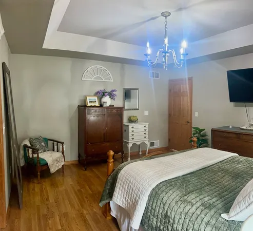 a bedroom with a bed and a chandelier