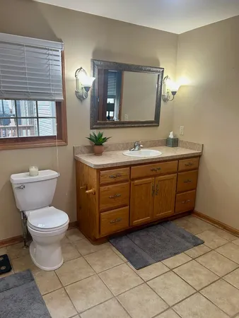 a bathroom with a toilet sink and mirror