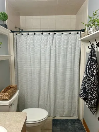 a bathroom with a toilet and a shower curtain