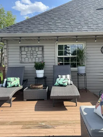 a view of a patio with couches chairs and wooden floor