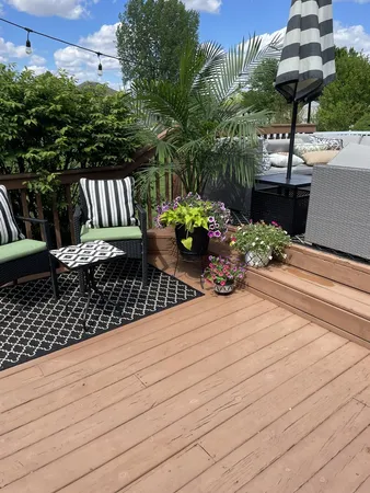 a view of a balcony with chairs potted plants