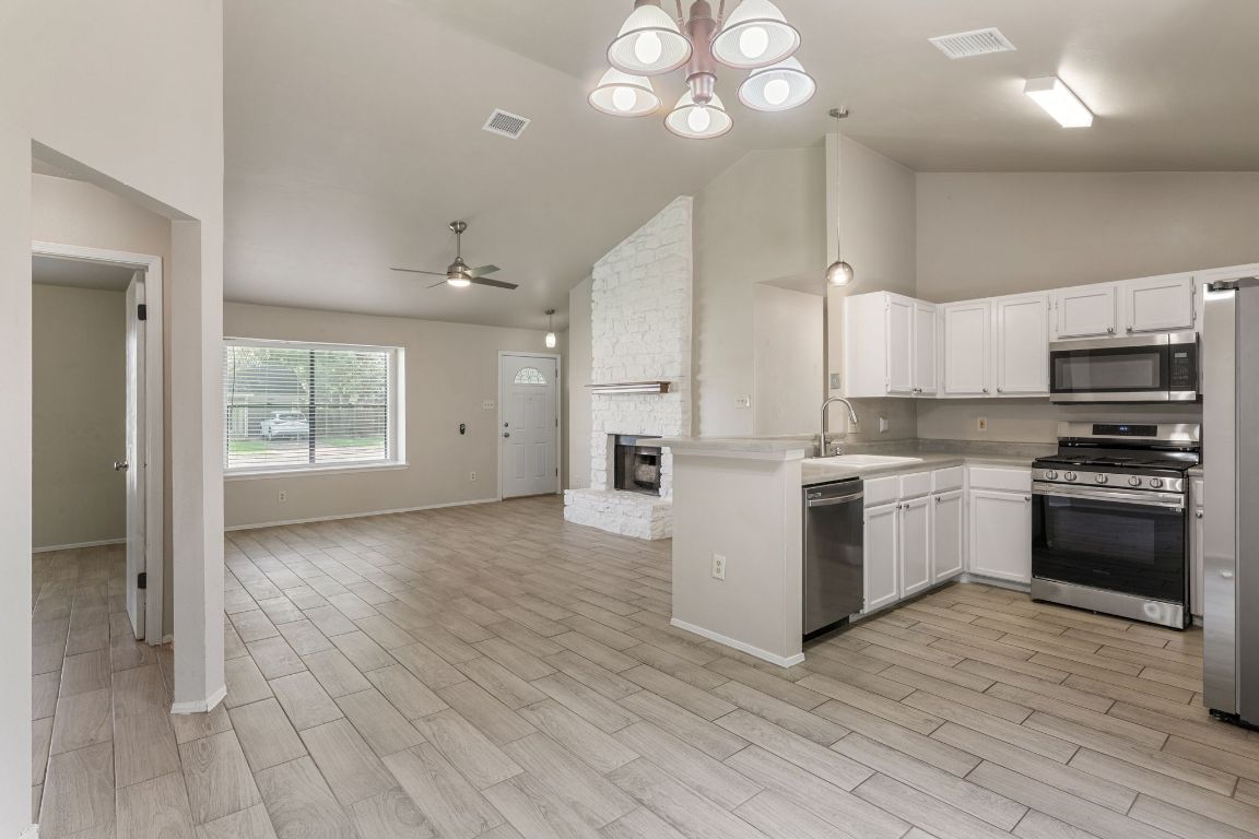 1808 Prairie Star Lane Round Rock, TX 78664 - Photo 31 of 32 a kitchen with granite countertop a stove top oven and cabinets