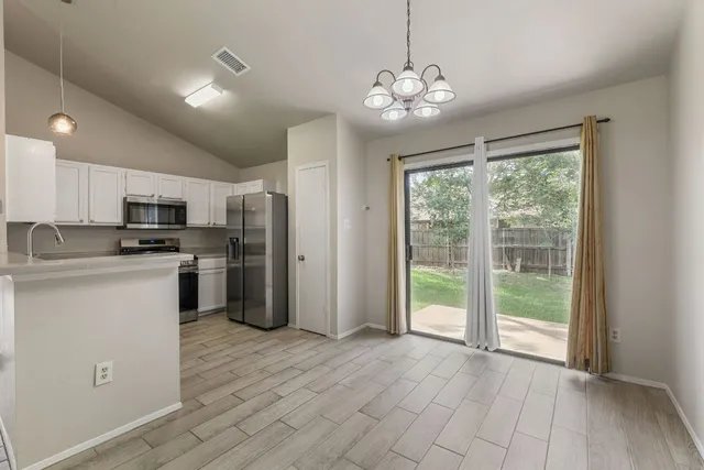 a kitchen with granite countertop a stove top oven and cabinets