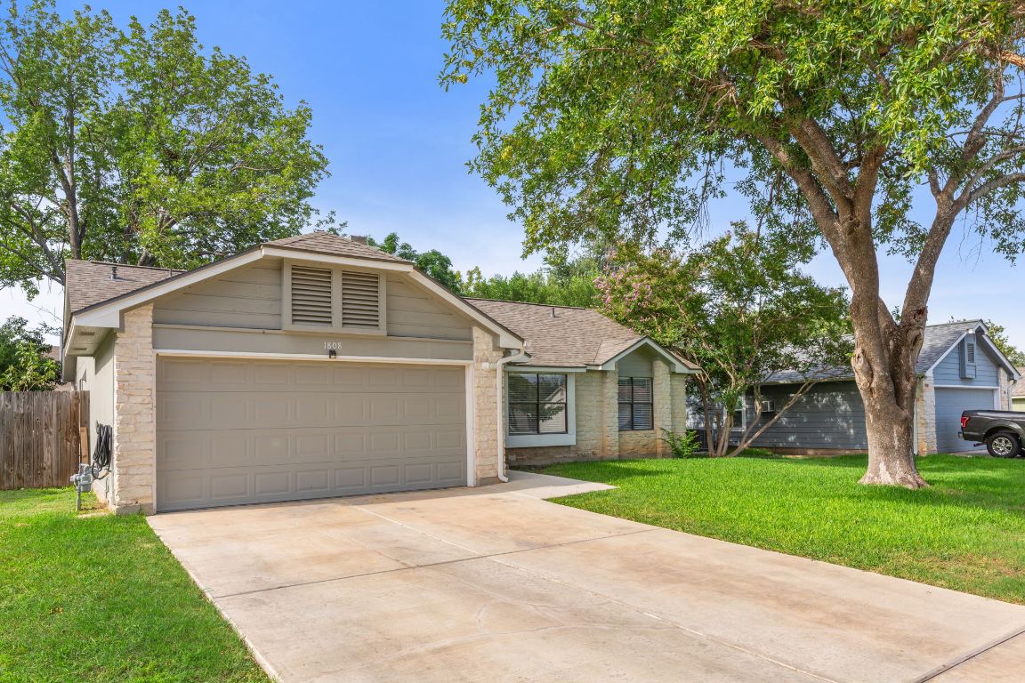 1808 Prairie Star Lane Round Rock, TX 78664 - Photo 4 of 32 a front view of a house with a yard and garage