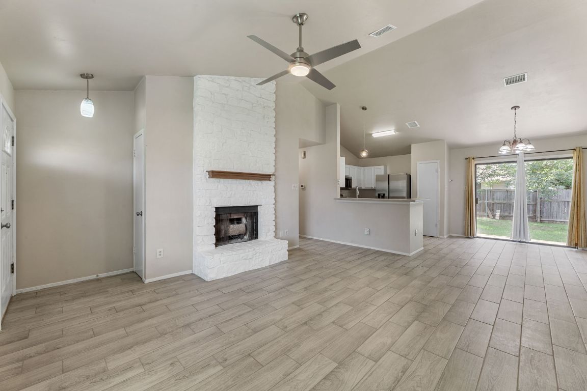1808 Prairie Star Lane Round Rock, TX 78664 - Photo 7 of 32 a view of a livingroom with a fireplace a ceiling fan and windows