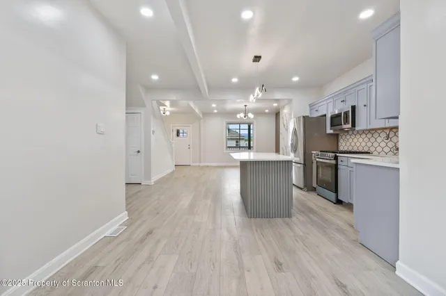 a view of kitchen with refrigerator sink and wooden floor