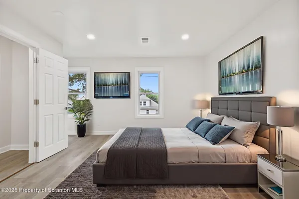 a bedroom with a large bed and a painting on the wall