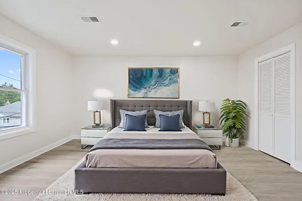 a bedroom with a large bed and a painting on the wall