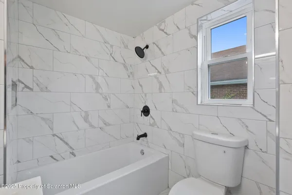 a bathroom with a toilet and a bathtub