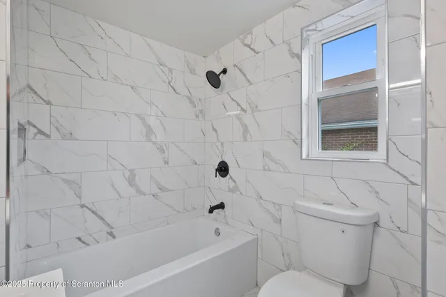 a bathroom with a toilet and a bathtub