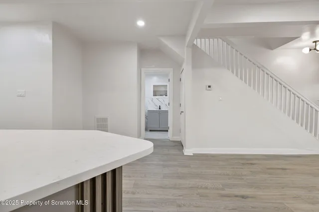a view of a hallway with wooden floor and staircase
