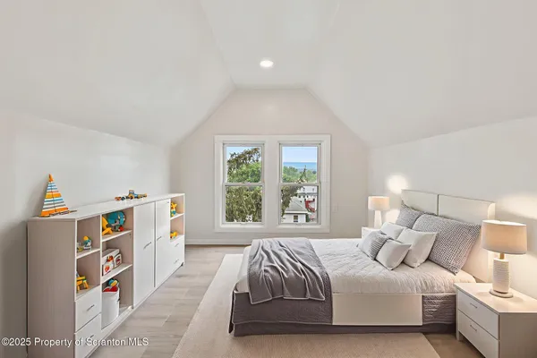 a bedroom with a bed and a large window