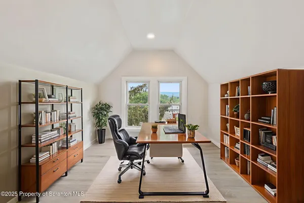 a living room with furniture a rug and a book shelf