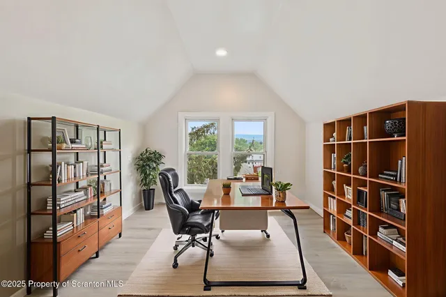 a living room with furniture a rug and a book shelf