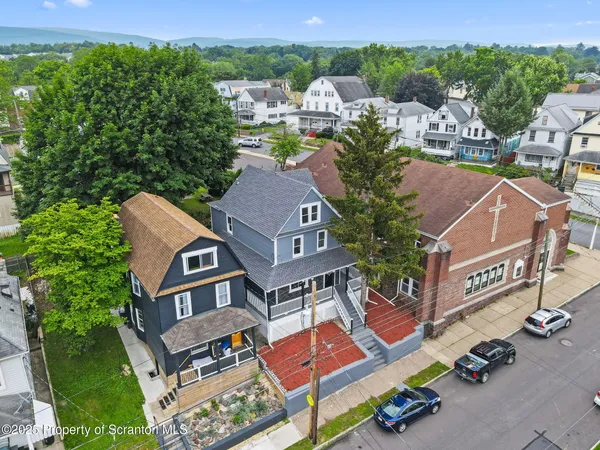 an aerial view of residential houses with outdoor space and trees