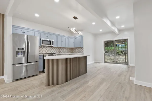 a kitchen with stainless steel appliances granite countertop a refrigerator and a sink