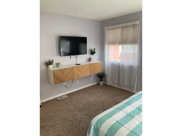 a bedroom with a bed and painting on the wall