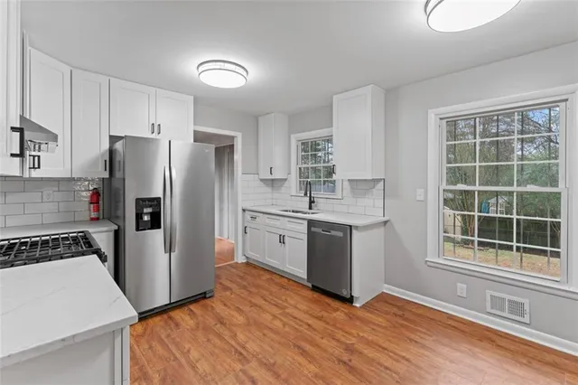 an empty room with windows and ceiling fan