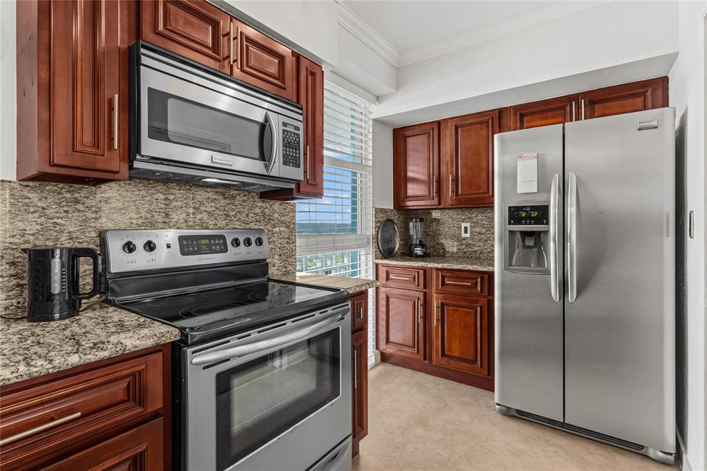 1900 South Ocean Drive, Unit 503 Fort Lauderdale, FL 33316 - Photo 16 of 33 a kitchen with stainless steel appliances granite countertop a stove microwave and refrigerator